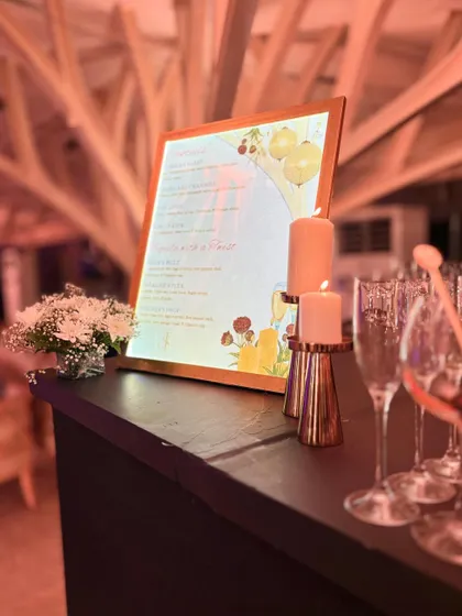 A candlelit bar scene showing our custom menu and glassware. The warm, soft lighting creates an intimate and luxurious atmosphere, perfect for an evening celebration.
