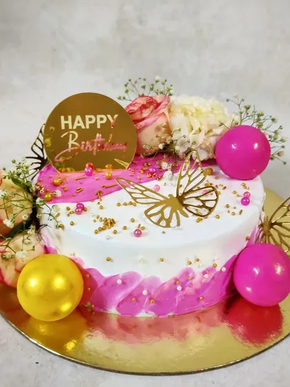 Pink, flowers, and butterflies are a perfect combination for a birthday cake. This design combines fresh roses with golden butterfly accents for a truly beautiful finish.