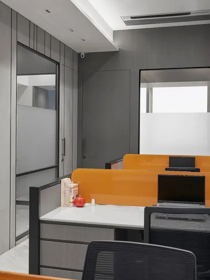 This open-plan office uses bright orange desk dividers to add a splash of energy. The layout is designed for collaboration, with ample storage and clean lines to ensure a clutter-free and productive environment.