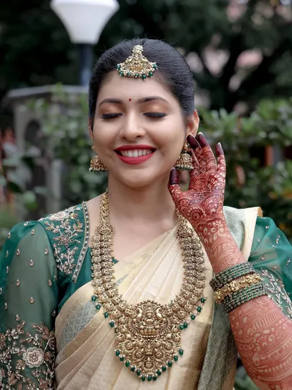 A bride’s smile is my greatest reward. This bride chose an elegant off-white Kanjeevaram silk saree with a rich emerald green border and a matching embroidered puff-sleeve blouse, proving that you don't need red to be a classic bride.