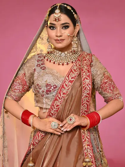 A beautiful example of a student's portfolio work. This look features sharp, defined eyes and a flawless base, paired with a unique brown and red lehenga.