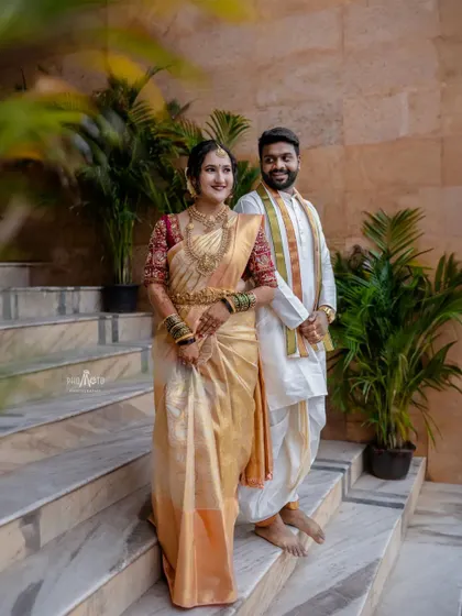 A full-length portrait of the couple, showcasing their elegant and coordinated traditional outfits.