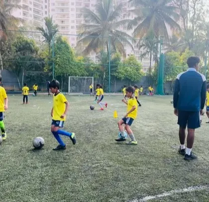 Players engaged in a dribbling drill during a morning session. Consistent practice with ball mastery is key to developing confident players.