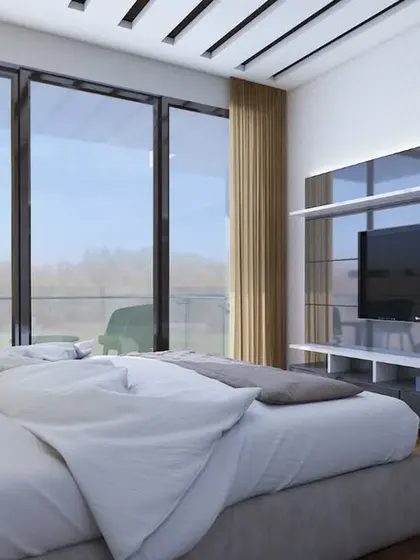 A master bedroom with a sleek, reflective TV unit and floor-to-ceiling windows that open to a balcony.