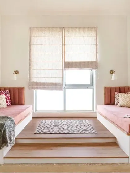 A cozy bedroom with two single daybeds in a warm pink upholstery, perfect for a shared room or guest space.