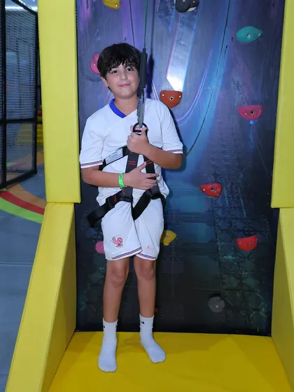 A young climber gets harnessed up and ready to tackle our indoor rock climbing wall. Safety is our first priority.