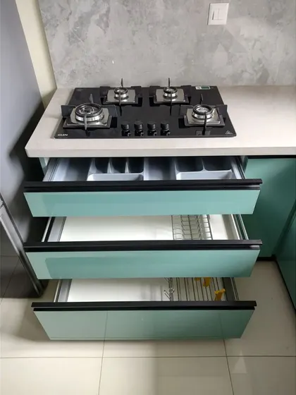 Smart drawer organization is key to a functional kitchen. Here, we have dedicated drawers for cutlery, plates, and larger utensils, all neatly arranged right below the hob for maximum convenience while cooking.