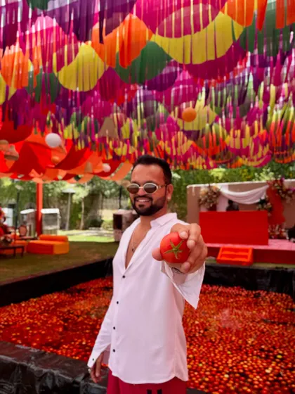 Holding up a tomato, ready for the La Tomatina festival to begin. I'm always up for hosting unconventional and adventurous themed parties.