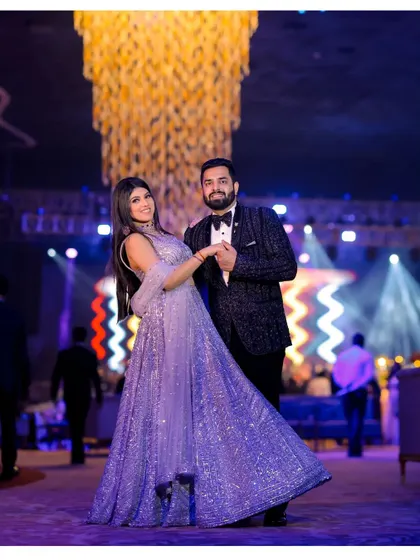 A beautiful dance pose under a grand chandelier, highlighting the elegance of the couple and the venue.