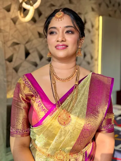 A close-up of the bride's makeup, showing the flawless base and the soft lip color that complements her saree.