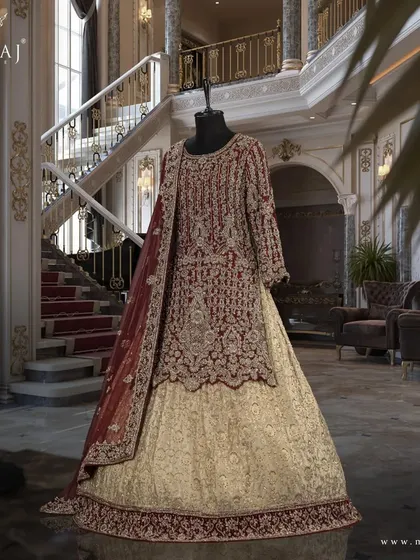A studio shot of the maroon scalloped long top and gold banarsi lehenga, a timeless addition to your collection.