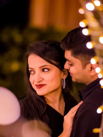 A close-up, intimate portrait using fairy lights to create a beautiful foreground bokeh. This technique adds depth and a touch of magic to this tender moment.