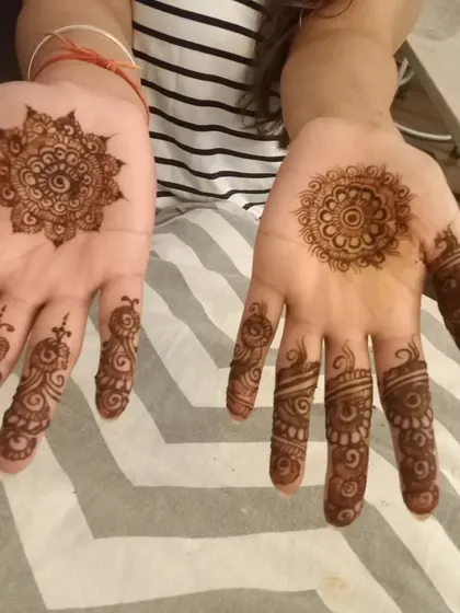 Two different styles of mandala mehendi for two friends, showing how the same concept can be customized.