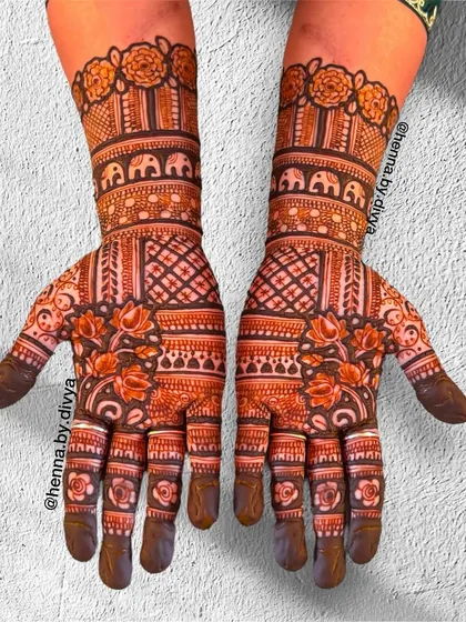 A symmetrical design filled with traditional Indian patterns. The arms feature bands of elephants, while the palms have a mix of lotus and geometric grid work.