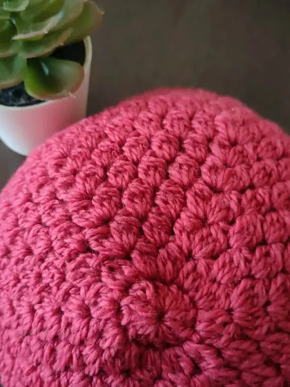 A top-down view of the Flora beanie, showing the neat crown created with cluster stitches. This is a great stash-busting project for using up leftover yarn.