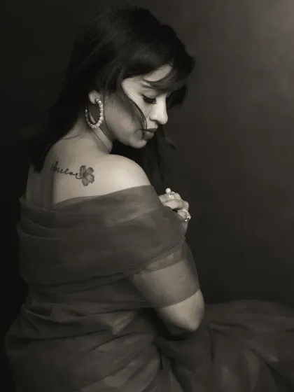 There is a unique power in monochrome. By stripping away color, we focus on the raw emotion, the subtle play of light on skin, and the story told in a single glance. This portrait captures a moment of quiet introspection, highlighting the delicate tattoo as a personal mark of her journey.