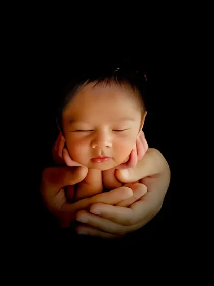 There is nothing more precious than a newborn. I created this artistic, low-key portrait to highlight the baby's delicate features, held safely in their parent's hands. It's a simple, powerful image that families treasure forever.