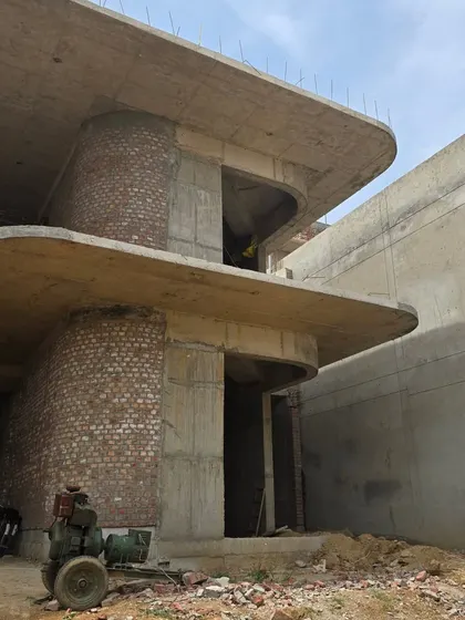 The facade of the Ludhiana project under construction, revealing the combination of curved concrete balconies and exposed brick infill walls. This shows our signature material palette taking shape on site.