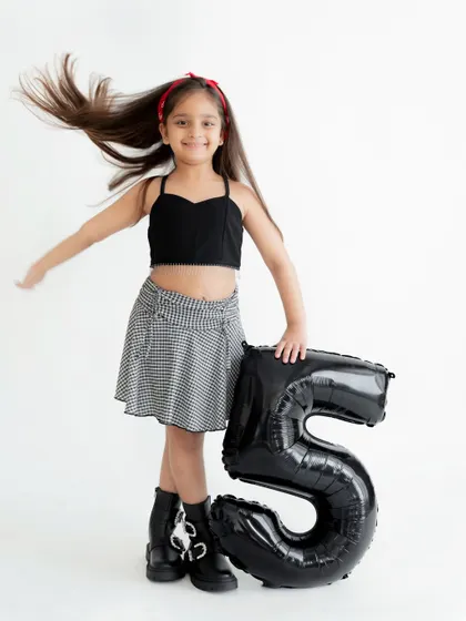 A dynamic shot with hair flying, capturing the fun and free spirit of being five years old during her studio birthday photoshoot.