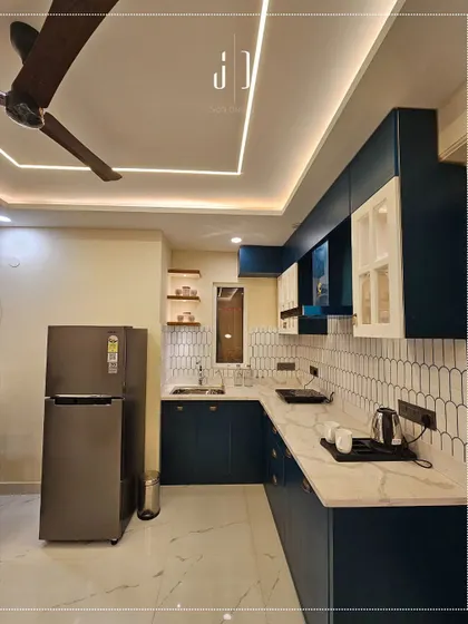 This kitchen in our Rishikesh project features a bold navy blue and white color scheme. The design is compact yet highly functional, with everything organized and within easy reach.