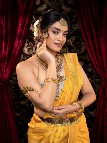 This image showcases the traditional way of draping a saree with a vaddanam, perfectly complemented by the antique jewellery set.