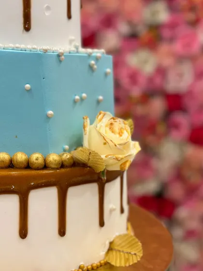A side view of the three-tiered engagement cake, highlighting the texture and the elegant combination of colors and decorations.