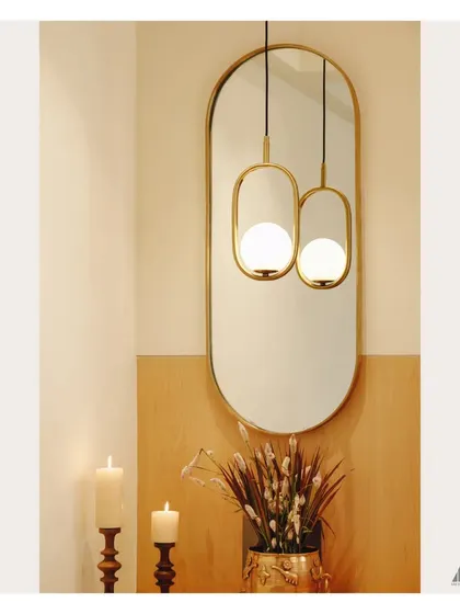 The reflection in the mirror doubles the impact of the stylish pendant light. This is a simple technique we use to enhance brightness and add depth to smaller spaces like foyers.