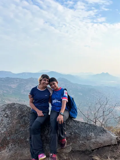 Two women taking a moment to enjoy the view and their friendship on a mountain trek. The outdoors is the perfect place to connect with friends.