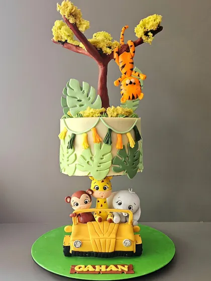 A closer look at this incredible jungle-themed topsy-turvy cake. The animals are on a safari jeep at the base, while the angled tiers above create a sense of adventure and fun.