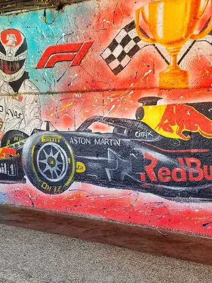 Another angle of the F1 section at Burnout Café, showing the Red Bull car ready to race past the checkered flags.