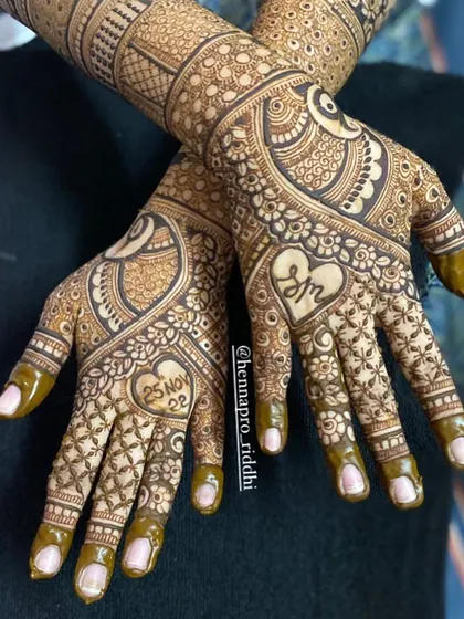 A beautiful back-hand design for a bride. This pattern includes heart-shaped frames for the wedding date and the couple's initials, surrounded by delicate floral work.