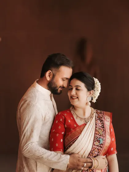 A beautiful close-up portrait showing the couple's gentle affection. The bride's traditional hairstyle with flowers and the soft lighting create a timeless and romantic feel.