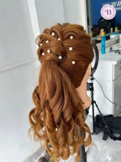 A beautiful high ponytail with curls and pearl accessories, created on a mannequin head. I teach a variety of modern and classic hairstyles in my course.