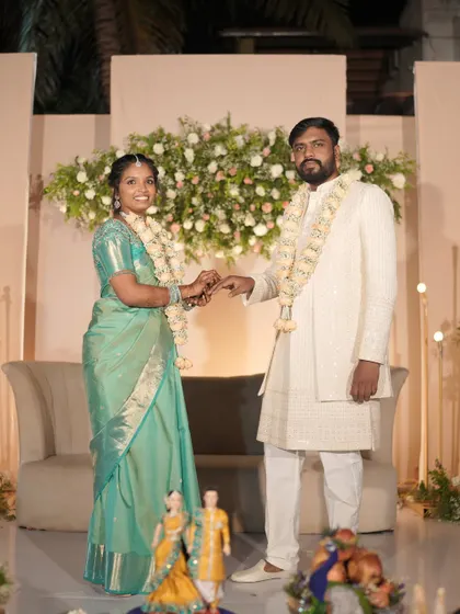 A portrait of the couple at their reception. The backdrop of soft florals and warm lighting creates a romantic setting for their first moments as a married couple.