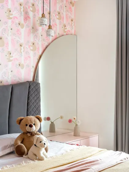 A detail of the daughter's room, showing the arched mirror and pink bedside table that complement the playful theme.