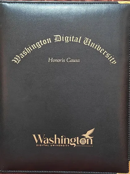The official folder from Washington Digital University containing the 'Honoris Causa' degree. This represents a significant academic honor awarded to our founder.