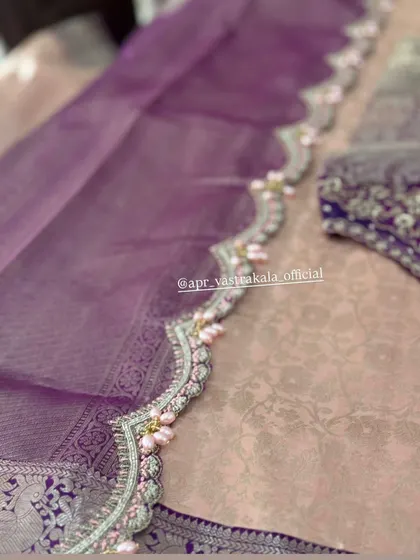 A scalloped border in lavender, detailed with silver zardosi and delicate pink pearl clusters, adding a soft, romantic touch.