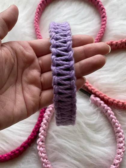 Detail shot of a lovely lavender macrame hairband. You can see the texture of the woven cord wrapped around the flexible band, making it a unique and stylish piece.