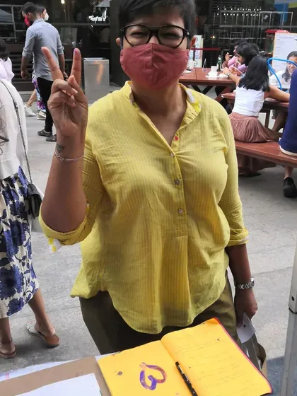 A happy visitor at my art stall, ready to dive into a creative session. I always keep a guestbook for people to share their thoughts and experiences.