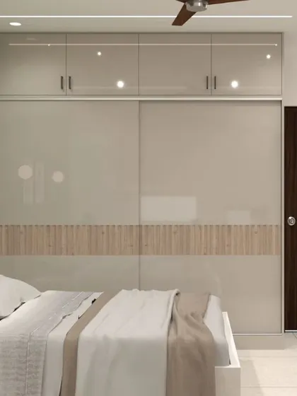 This image shows the large sliding wardrobe in the same bedroom. The glossy beige doors with a central fluted wood panel complement the room's natural and serene color scheme.