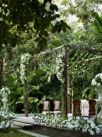Another perspective of the serene white and green mandap, highlighting its harmonious integration with the garden venue.