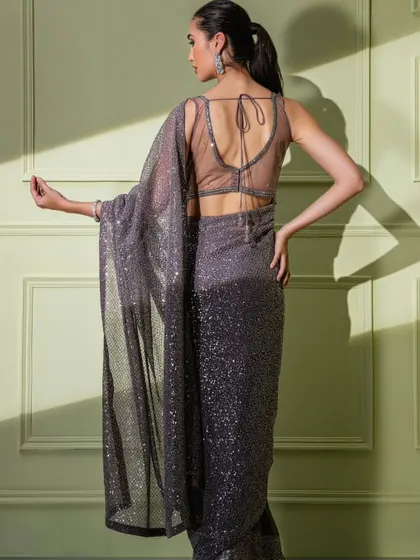 The sheer, alluring back of the grey ombre sequin saree's blouse.