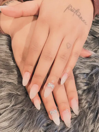 A subtle and elegant choice for a bride. These are natural-looking translucent extensions with delicate silver glitter bow accents.