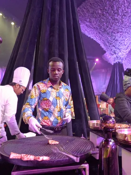 A chef from our international team grills meat at a live station. The vibrant colours of his attire and the focused action of grilling create a dynamic and engaging scene for guests.
