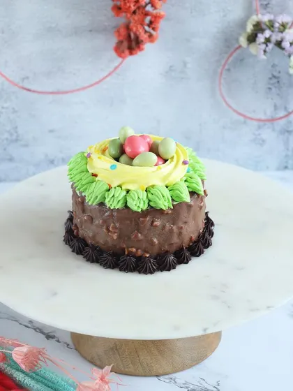 A nutty chocolate Easter cake decorated to look like a bird's nest with candy eggs.