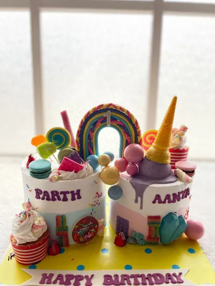 A Candyland cake I made for twins. Each side is personalized but shares a common theme of sweets, ice cream, and bright colors.