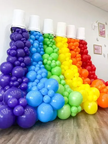 A creative and colorful balloon sculpture that looks like paint spilling from buckets, showcasing our ability to create unique, custom balloon art.
