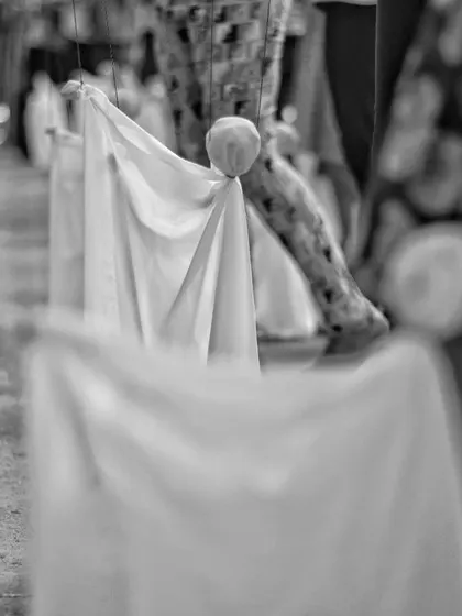 A close-up, artistic shot of the puppets made during a summer camp. The shallow focus emphasizes the texture of the cloth and the simple form of the characters.