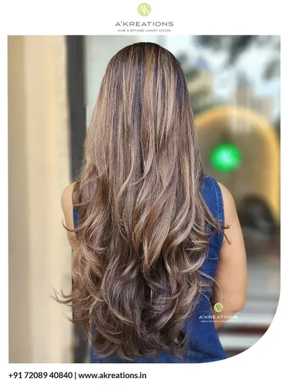 We created these beautiful, warm caramel and golden highlights on long hair, finished with layers and soft waves for a sun-kissed, dimensional look.