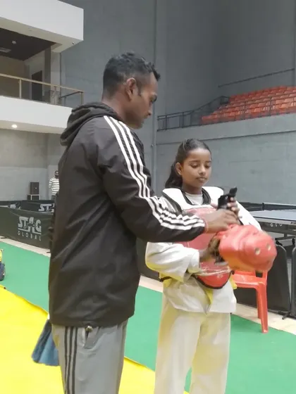 A coach fits a young girl with her protective gear before a Taekwondo match. Ensuring the safety of our athletes is paramount in all the sports and events we support.